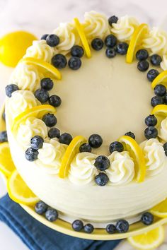 a white cake with blueberries and lemons on top