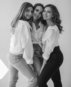 three young women are posing together in black and white, one is leaning on the back of another woman's head