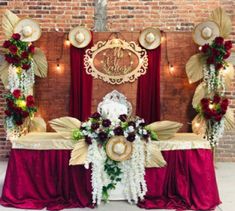 a red and gold wedding ceremony setup with flowers on the headpieces, candles, and other decorations