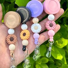 a hand holding several different colored flower shaped items