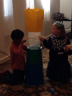 two young children playing with an object on the floor