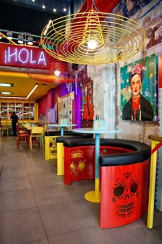 the interior of a restaurant with brightly colored booths and tables in front of large posters