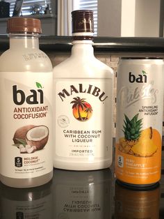 three bottles of various types of alcohol sitting on a counter