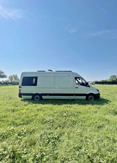 a white van parked in the middle of a field