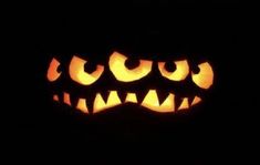 a carved pumpkin with glowing eyes in the dark