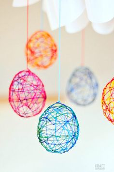 three colorful balls are hanging from strings