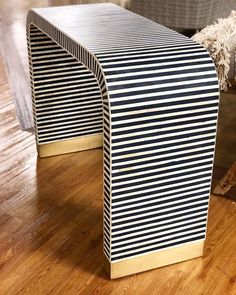 a black and white striped table sitting on top of a wooden floor