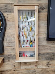 a clock mounted to the side of a wall with fishing lures on display in it