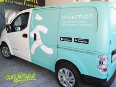 a blue and white van parked in front of a building with the words milkman on it