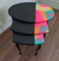 three black tables with different colored tops on wooden floor next to white radiator