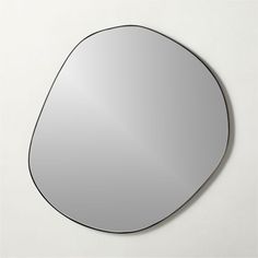 a mirror that is on the wall in front of a white background with black trim