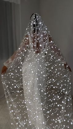 a woman wearing a veil with white stars on it