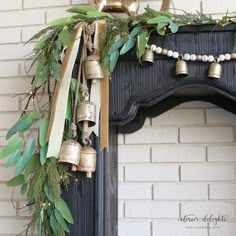 an old fireplace decorated with greenery and bells