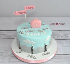 a birthday cake with the name karola on it and a pink suitcase sitting on top