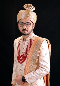 a man in a turban and suit posing for a photo with his hands on his hips