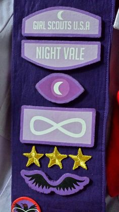 the girl scouts usa night vale badge is purple with gold stars and an eye patch