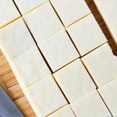 cut up pieces of cheese sitting on top of a cutting board