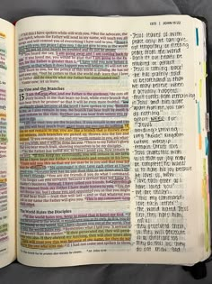 an open bible with many different colored words on it's pages and in the middle