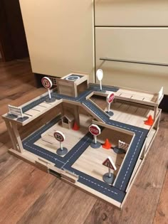 a play set with cars and stop signs on the road in front of an oven