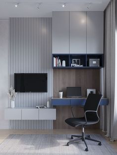 an office with a desk, chair and television on the wall in front of it