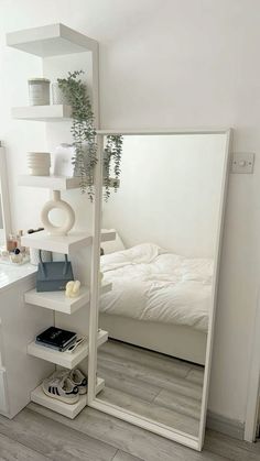 a bedroom with a bed, mirror and shelves on the wall in front of it