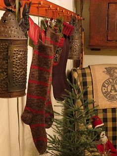 christmas stockings hanging from hooks on the wall next to a tree and other holiday decorations