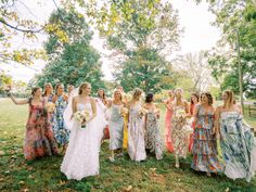 a group of women standing next to each other on top of a lush green field