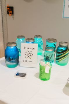 there are many jars on the table with blue and green liquid in them, labeled science lab no 1