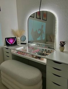 a vanity with a mirror, stool and various makeup products on it in a room