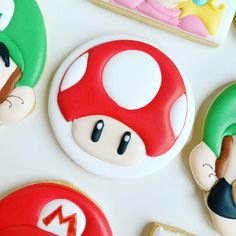 some cookies are decorated with mario and luigi's faces on them, all in different colors