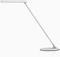 a desk lamp that is on top of a white surface with the light turned on