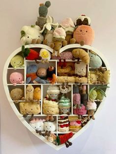 a heart shaped shelf filled with lots of stuffed animals