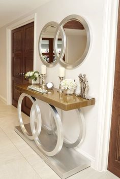 a console table with two circular mirrors on it