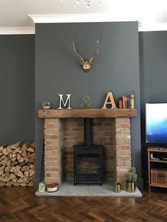 a living room with a fire place and wood stacked on top of each other in front of a tv