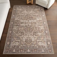 a large area rug with an ornate design on the floor in front of a white couch