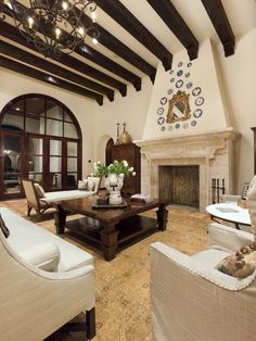 a living room with couches, chairs and a fire place in the middle of it