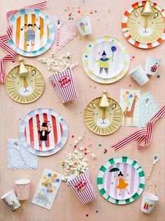 paper plates with animals and circus themed decorations on them are laid out on a table