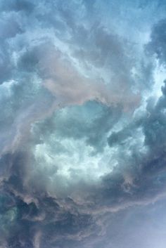 an airplane is flying through the cloudy sky