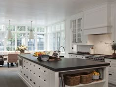 a large kitchen with an island in the middle and lots of cabinets on both sides