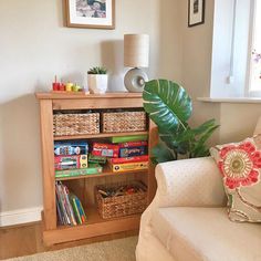 a living room with a couch, chair and bookshelf filled with children's toys