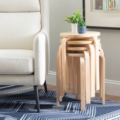 three wooden stools stacked on top of each other in front of a white chair