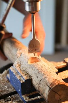 a person using a drill to cut wood