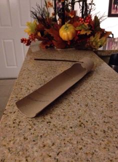 a knife sitting on top of a counter next to a vase filled with autumn leaves