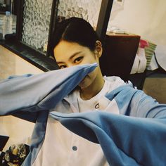 a woman covering her face while sitting at a table