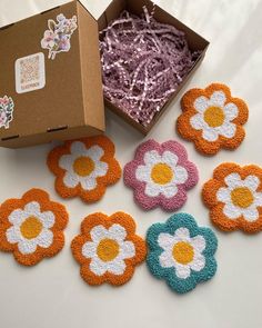 six crocheted flower coasters in a box