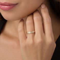 a woman wearing a gold ring with the word love engraved on it's side