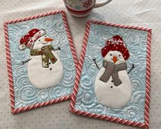 two snowman coasters on a table with a coffee cup in the middle and another one wearing a red hat