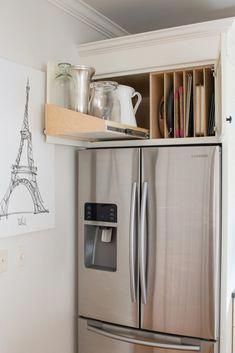 a kitchen with a refrigerator and shelves filled with utensils