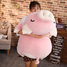 a woman holding a large pink stuffed animal