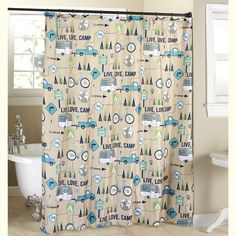 a bathroom with a shower curtain that has trees on it and the words live, love, camp